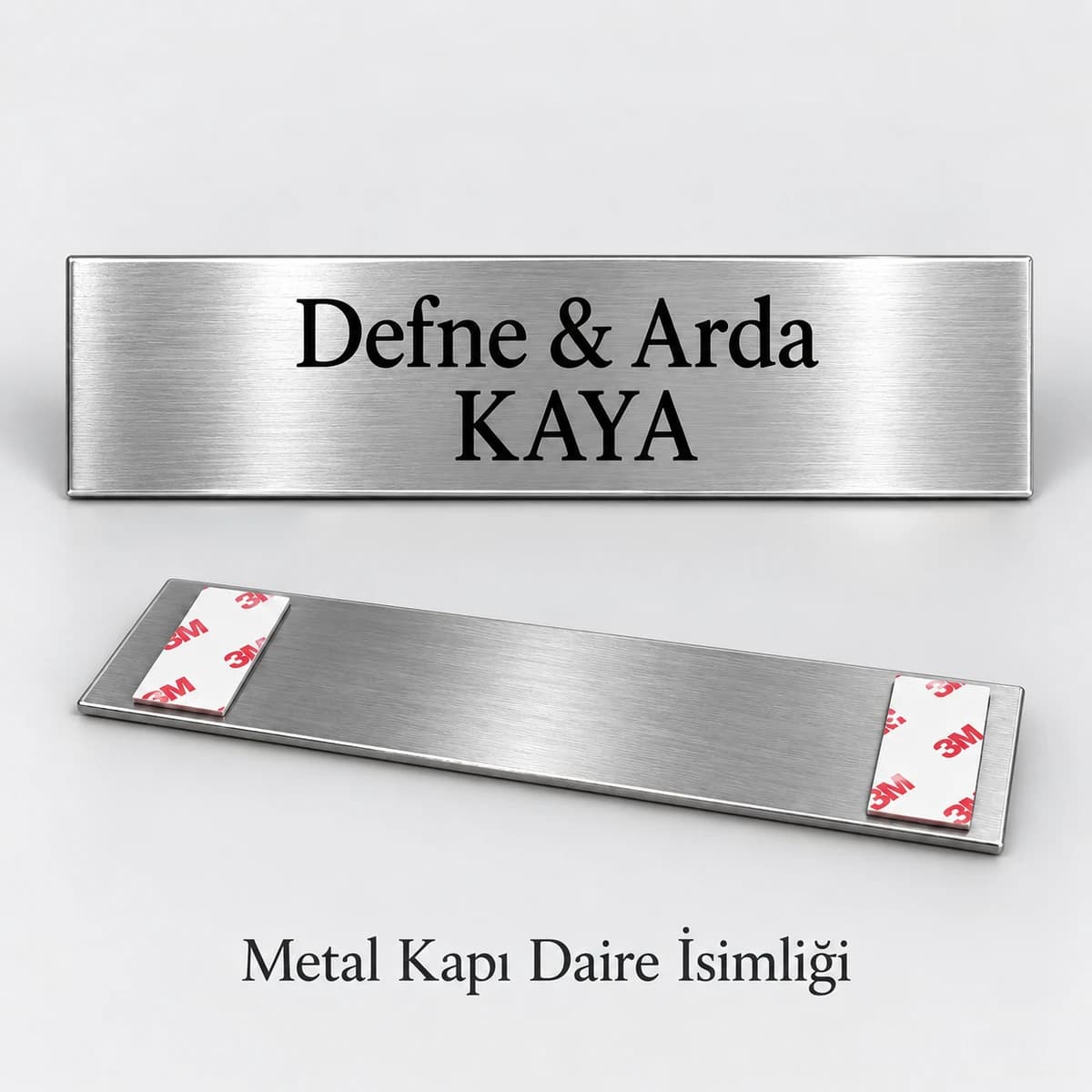 Gümüş Metal Kapı İsimliği İki isim ve soyadı yazılı gümüş rengi fırçalı metal kapı isimliği, arkasında yapışkan bant